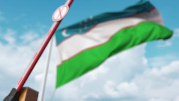 Cancello a braccio chiuso con cartello STOP CORONAVIRUS sullo sfondo della bandiera uzbeka. Quarantena in Uzbekistan — Video Stock