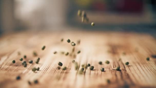 Lentilhas verdes espalham-se na mesa de madeira, tiro de close-up de câmera lenta — Vídeo de Stock