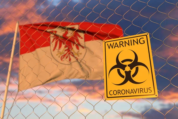 Biohazard coronavirus sign against flying flag of Brandenburg, a state of Germany (en inglés). Renderizado 3D relacionado con cuarentena —  Fotos de Stock