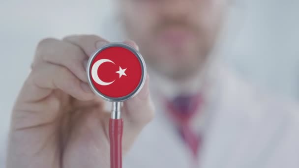 Az orvos sztetoszkópot használ a török zászlóval. Egészségügyi ellátás Törökországban — Stock videók