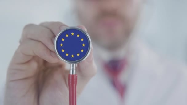 Doctor escuchando con el estetoscopio con bandera de la UE. Sanidad europea — Vídeos de Stock