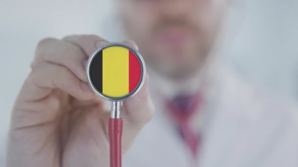 Dokter luisterend met de stethoscoop met vlag van België. Belgische gezondheidszorg — Stockvideo