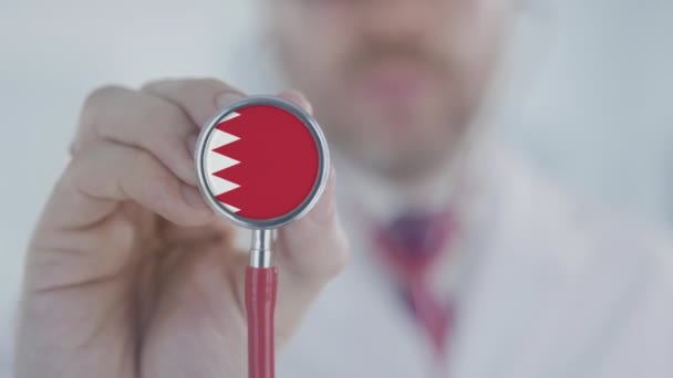 Az orvos sztetoszkópot használ a bahreini zászlóval. Egészségügyi ellátás Bahreinben — Stock videók