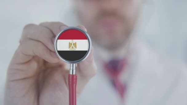 Doctor holds stethoscope bell with the Egyptian flag. Healthcare in Egypt — Stock Video