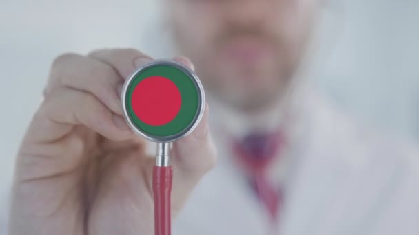 Doctor escuchando con el estetoscopio con la bandera de Bangladesh. Asistencia sanitaria en Bangladesh — Vídeo de stock