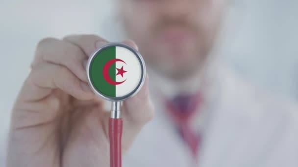 医生正在听带有阿尔及利亚国旗的听诊器。阿尔及利亚保健 — 图库视频影像
