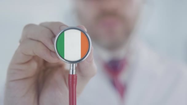 Doktor používá stetoskop s irskou vlajkou. Zdravotní péče v Irsku — Stock video