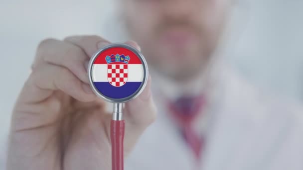 Doctor holds stethoscope bell with the Croatian flag. Healthcare in Croatia — Stock Video