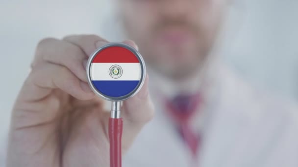 Arzt hört mit dem Stethoskop mit Flagge Paraguays zu. Paraguayische Gesundheitsversorgung — Stockvideo