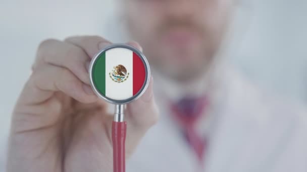 El doctor sostiene la campana del estetoscopio con la bandera mexicana. Salud en México — Vídeos de Stock