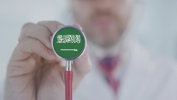 Doktorn använder stetoskop med Saudiarabiens flagga. Hälsovård i Saudiarabien — Stockvideo