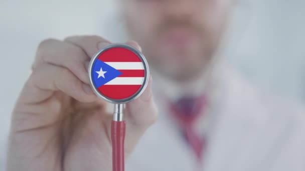 Az orvos sztetoszkóp harangot tart a Puerto Ricó-i zászlóval. Egészségügyi ellátás Puerto Ricóban — Stock videók