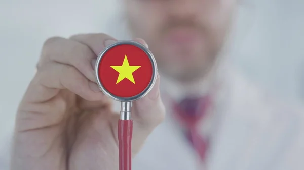 Doctor holds stethoscope bell with the Vietnamese flag. Healthcare in Vietnam — Stock Photo, Image