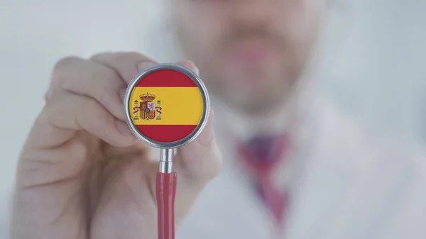 Médecin à l'écoute avec le stéthoscope avec drapeau d'Espagne. Soins espagnols — Photo