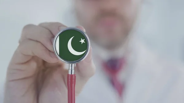 Medical doctor listening with the stethoscope with flag of Pakistan. Pakistani healthcare — Stock Photo, Image