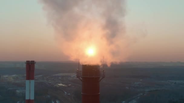 Letecký záběr odhaluje večerní slunce za znečišťujícím komínem kouře — Stock video