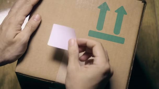 Человек маркирует коробку наклейкой CORONAVIRUS VACCINE — стоковое видео