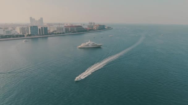 Luftaufnahme eines Kreuzfahrtmotorbootes und einer unbekannten verankerten Luxus-Motorjacht vor der Küste von Dubai, VAE — Stockvideo