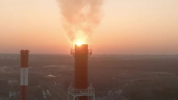 Fotografia aérea do pôr do sol atrás da pilha de fumaça industrial — Fotografia de Stock
