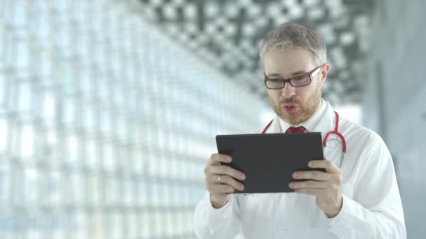 Arzt mit seinem Tablet-PC für telemedizinische Kommunikation mit einem Patienten. Schuss auf rote Kamera — Stockvideo