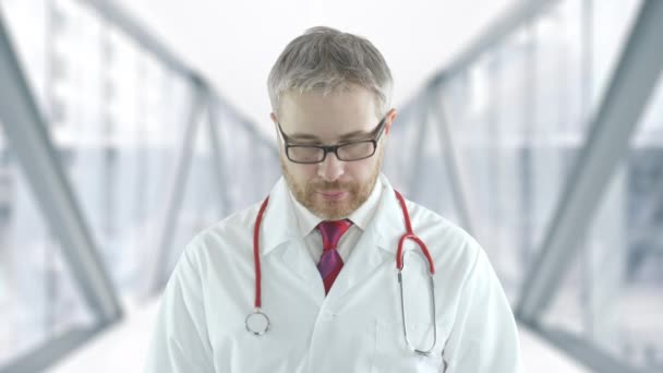 Retrato de un médico sonriente en el pasillo de cristal del hospital — Vídeos de Stock