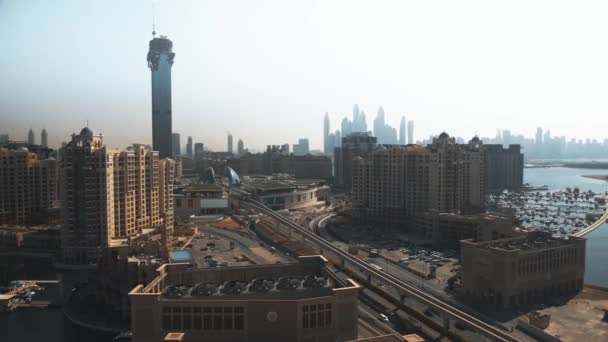 DUBAI, UNITED ARAB EMIRATES - 2019 년 12 월 28 일. 공중에서 본 나킬 몰과 팜 주메이라 섬에 있는 모노레일 역 — 비디오