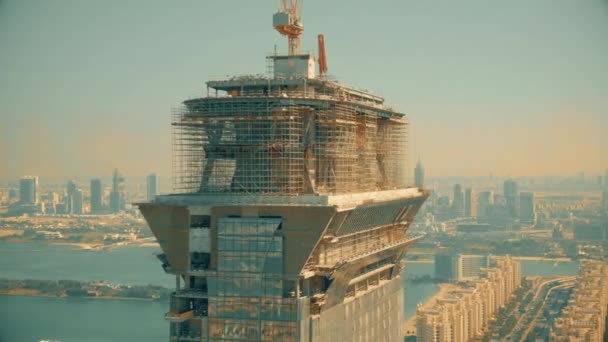 ドバイ、アラブ首長国連邦- 2019年12月28日。パームジュメイラ島に建設中のパームタワー超高層ビルの空中写真 — ストック動画