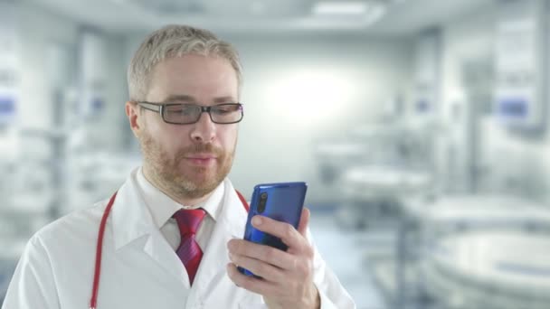 Médecin barbu parle sur son smartphone à un patient. Tourné sur caméra rouge — Video