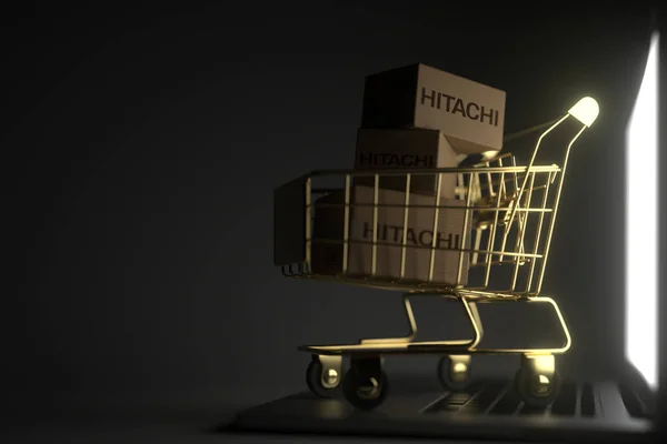 Three cartons with HITACHI logo in golden shopping cart on the laptop. Editorial premium service related 3D rendering — Stock Photo, Image