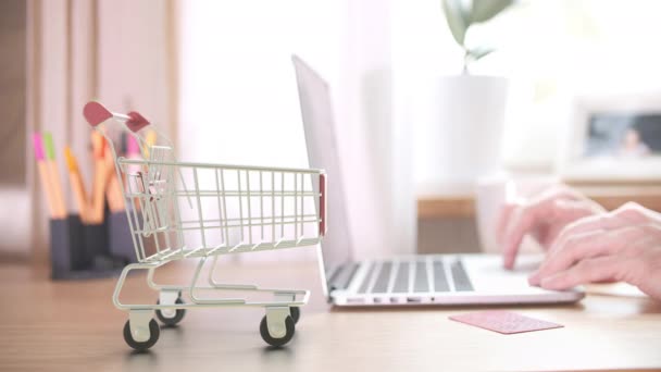 Caixas com logotipo AMAZON caem no carrinho de compras perto do cliente com laptop. Editorial compras on-line de casa animação 3D — Vídeo de Stock