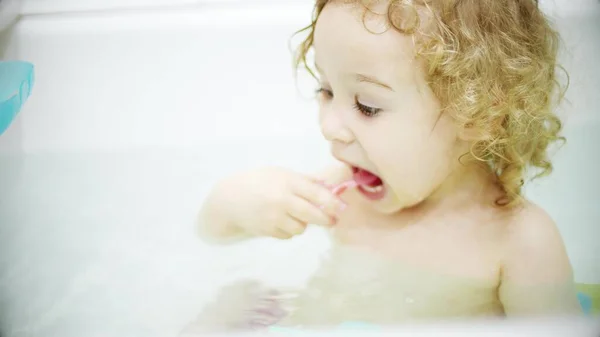 Kleines blondes Baby putzt sich im Badezimmer die Zähne — Stockfoto