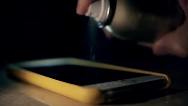 Spraying alcohol disinfectant to sanitize the smartphone, slow motion shot. Hygiene during coronavirus outbreak — Stock Video