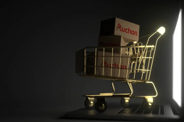 Krabice s logem AUCHAN ve zlatém nákupním košíku na klávesnici počítače. Editorial premium online service related 3D rendering — Stock fotografie
