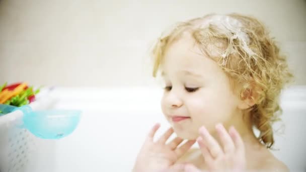Adorable petite fille blonde lave son visage et ses cheveux dans la salle de bain — Video