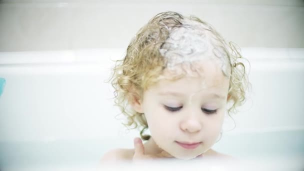 Adorabile ragazza bionda si lava il viso e i capelli nella vasca da bagno — Video Stock