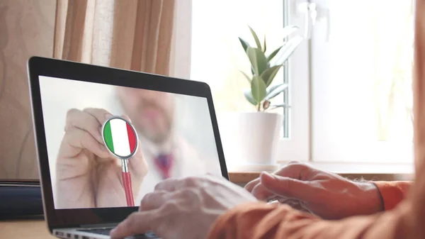 의사들은 집에 있는 랩탑 과 이탈리아 국기가 달린 청진기 종소리를 비디오로 방송한다. 이탈리아에 있는 선교 인들 — 스톡 사진
