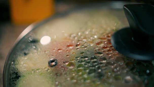 Wet glass cover of a frying pan, cooking vegetables at home macro shot — Stock Video