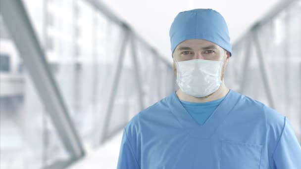 Γιατρός με μάσκα προσώπου σε γυάλινο διάδρομο νοσοκομείου κατά τη διάρκεια της επιδημίας του ιού της νόσου COVID-19. — Αρχείο Βίντεο