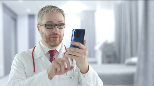 Az orvos a mobilját használja egy beteggel való telemedicinális videohíváshoz. — Stock Fotó