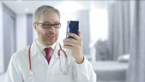 Médico alegre usa seu telefone celular para chamada de vídeo telemedicina com um paciente — Vídeo de Stock