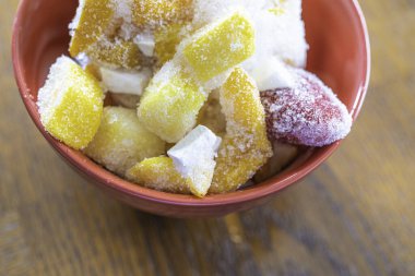 Buzlu meyve suyu hazırlamak için kırmızı bir kasede dondurulmuş meyve parçaları.