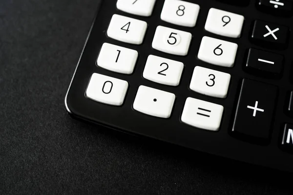 Schwarzer Taschenrechner im Büro auf schwarzem Hintergrund — Stockfoto