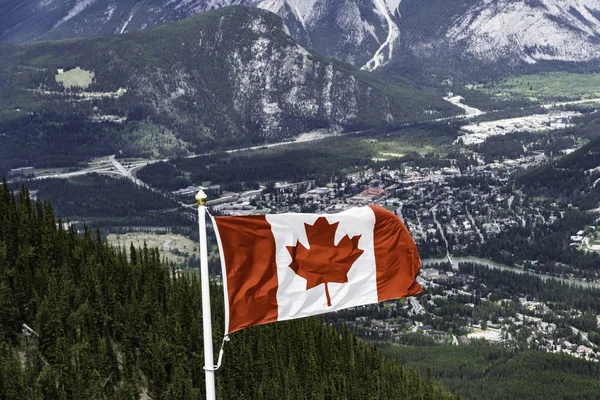 Прапор Канадського кленового листя летить через гори — стокове фото