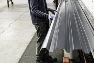 Bir fabrikada üretilen çatılı metal levhalar.