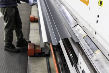 Bir fabrikada üretilen çatılı metal levhalar.