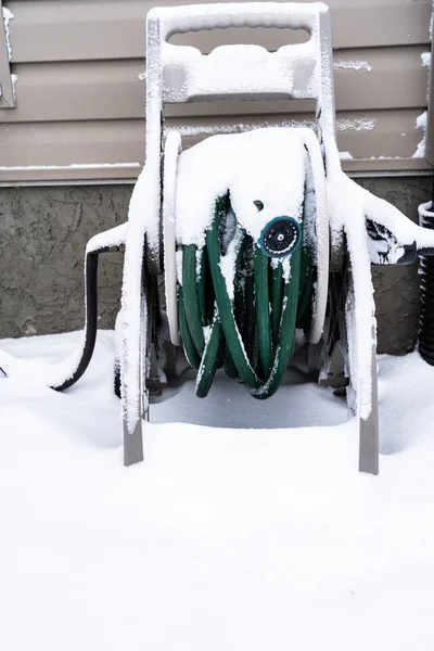 Kışın evin dışındaki bahçe hortumu karla kaplıydı.