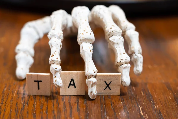 Señal de impuestos con la mano esqueleto - Concepto de impuestos de defunción —  Fotos de Stock