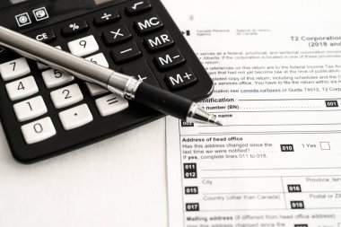 Şirket vergisini hesaplamak için hesap makinesiyle birlikte Kanada Vergi T2 iade formu