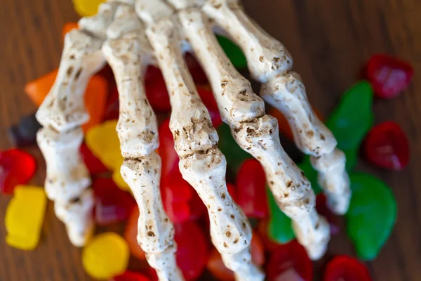 Skeleton hand offering bowl of Candy during halloween