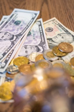 Cam kavanozdan dökülen bozuk paralarla kaplı banknotlar.